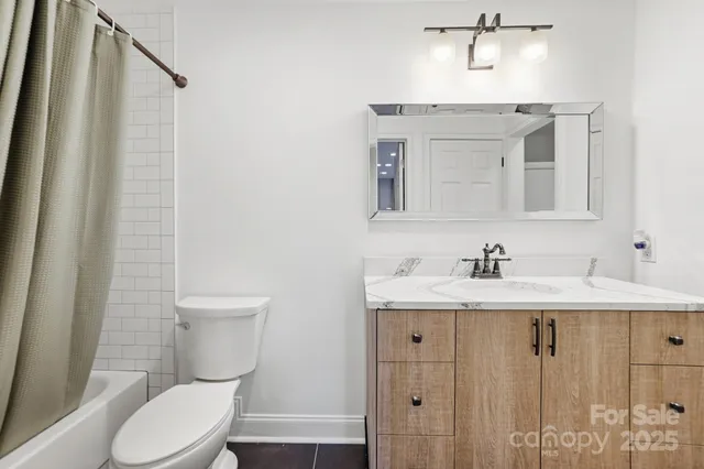 a bathroom with a toilet sink a mirror and vanity
