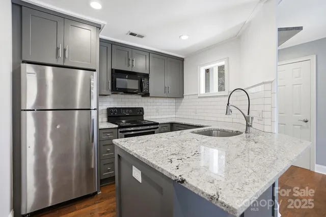 a kitchen with granite countertop a refrigerator and a sink
