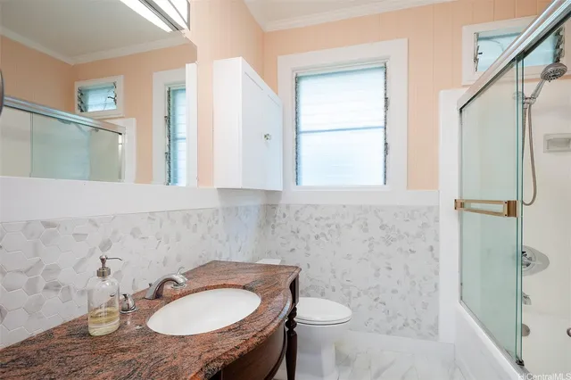 a bathroom with a sink toilet a mirror and shower