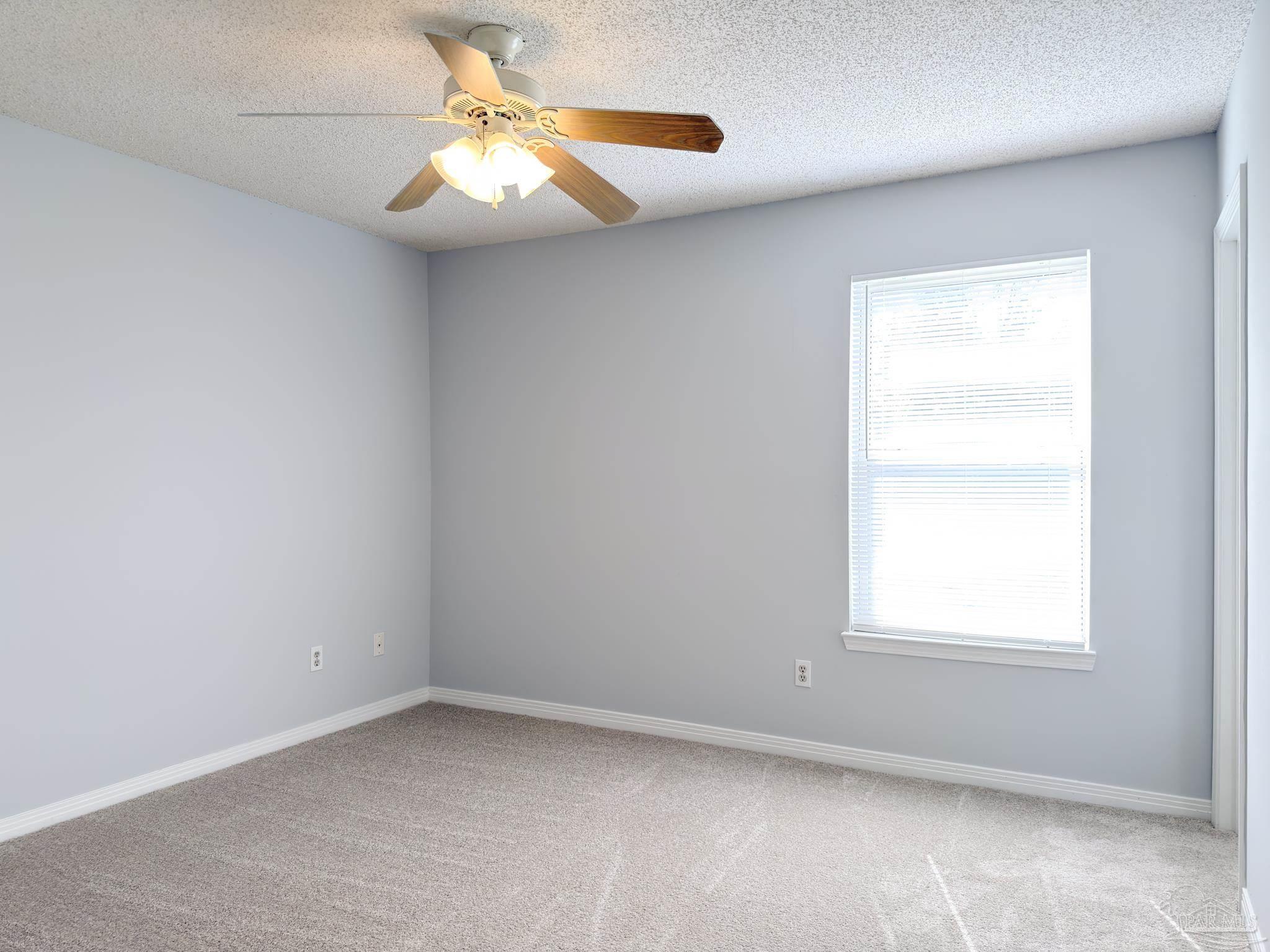 1341 Dog Track Road Pensacola, FL 32506 - Photo 11 of 26 an empty room with a window and a fan