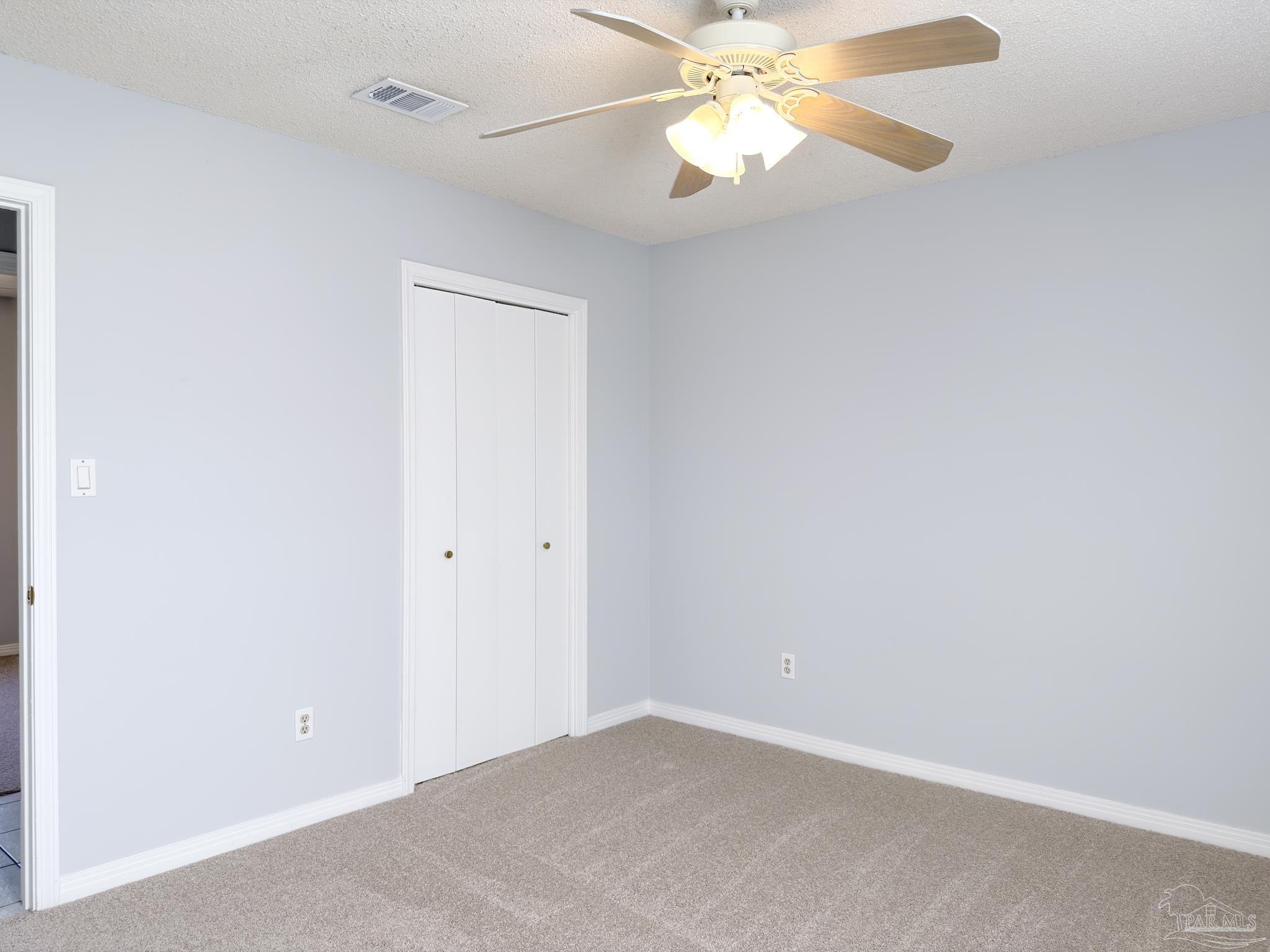 1341 Dog Track Road Pensacola, FL 32506 - Photo 12 of 26 an empty room with a chandelier fan and a window