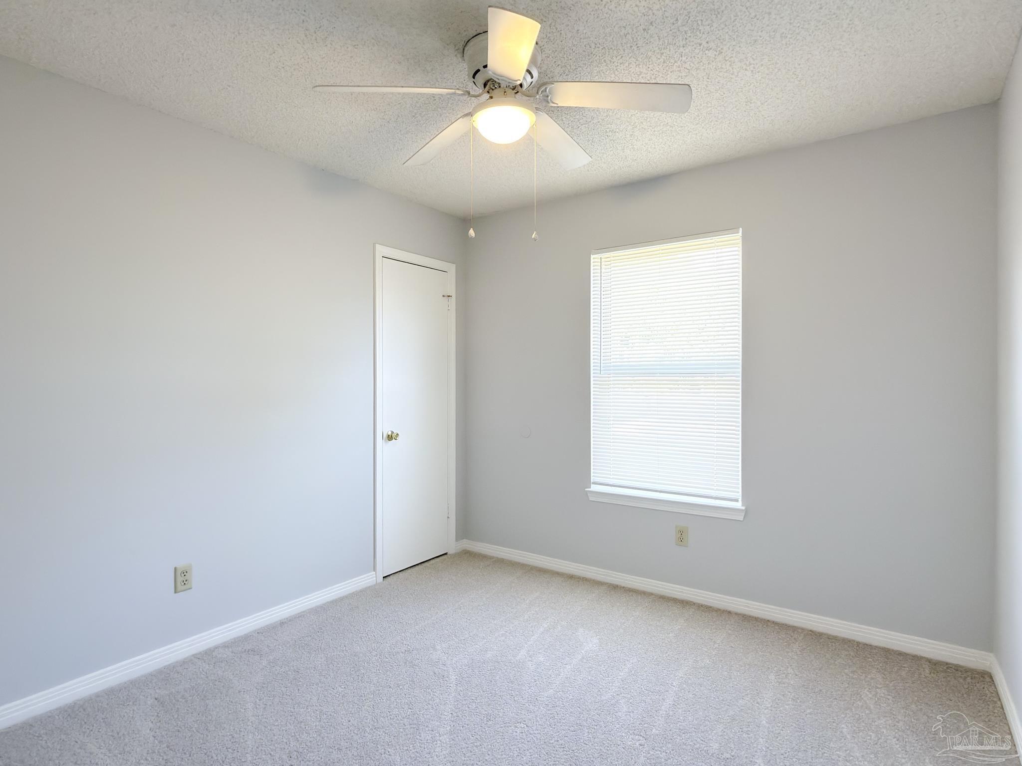 1341 Dog Track Road Pensacola, FL 32506 - Photo 15 of 26 an empty room with a window and a fan