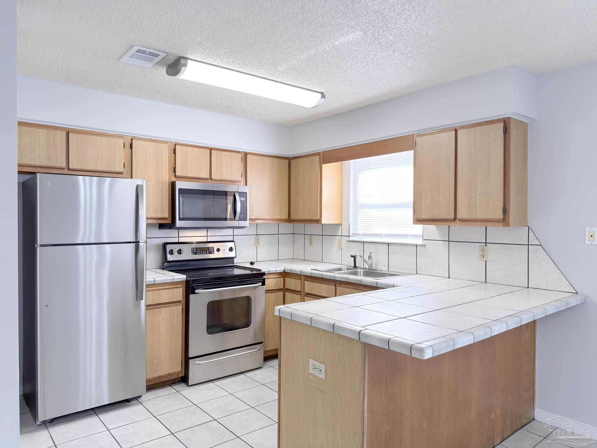 1341 Dog Track Road Pensacola, FL 32506 - Photo 6 of 26 a kitchen with granite countertop a sink stove and refrigerator