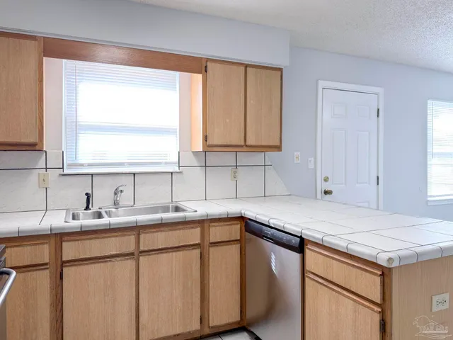 a kitchen with a sink cabinets and window