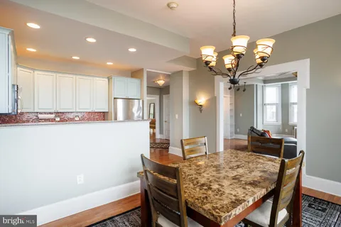 a dining room with wooden floor and chandelier