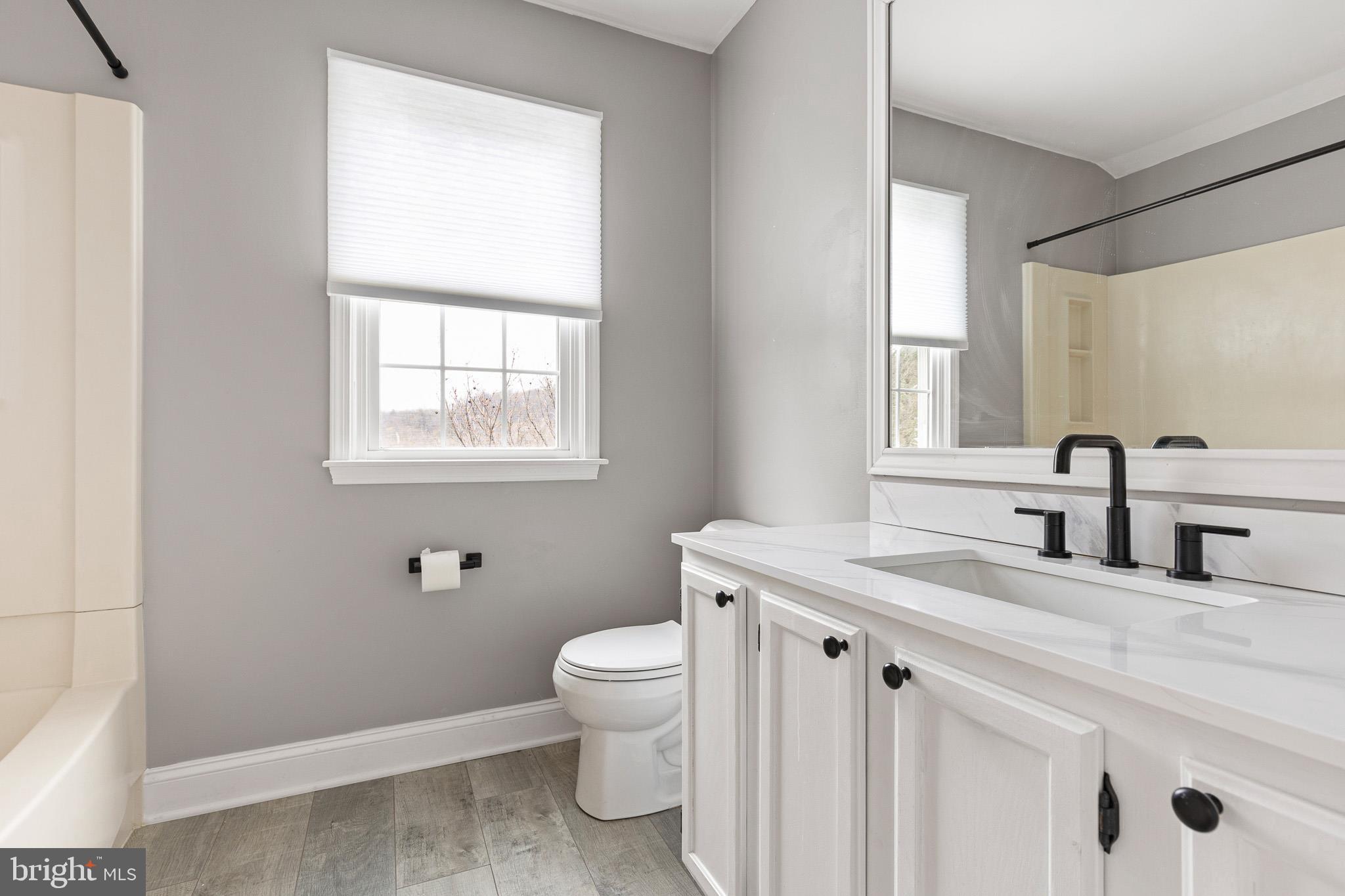 719 Jacques Circle Chester Springs, PA 19425 - Photo 23 of 31 a bathroom with a granite countertop toilet a sink and a window
