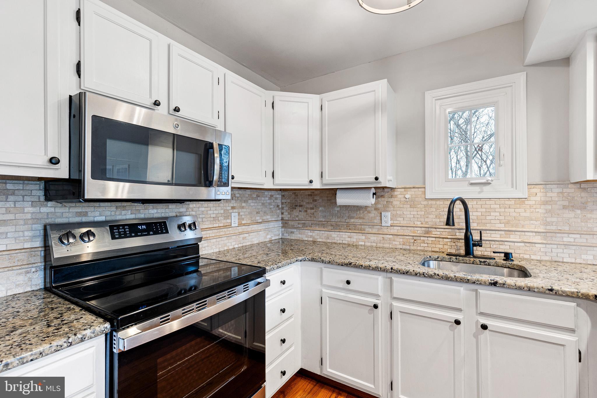 719 Jacques Circle Chester Springs, PA 19425 - Photo 10 of 31 a kitchen with granite countertop a sink cabinets and stainless steel appliances