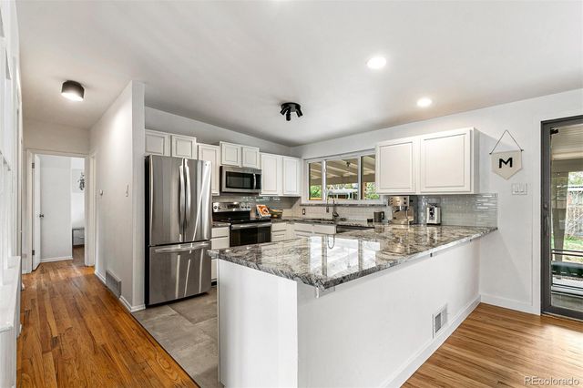 a kitchen with stainless steel appliances granite countertop a refrigerator and a sink