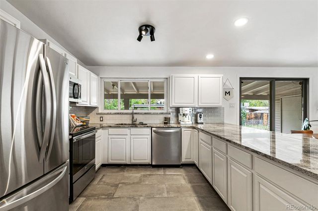 a kitchen with stainless steel appliances granite countertop refrigerator sink and stove