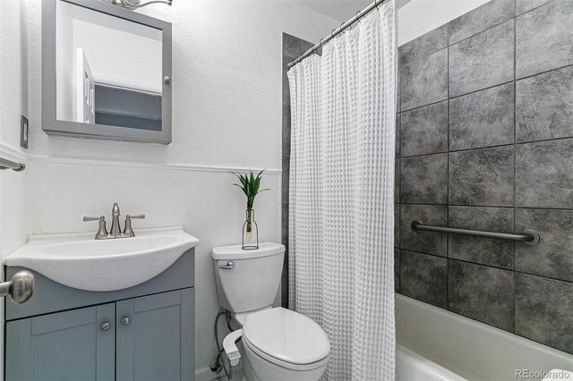 a bathroom with a sink a toilet a mirror and shower