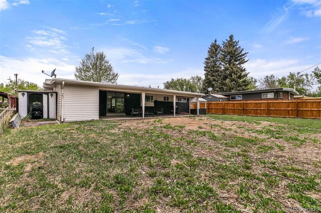 a backyard of a house with table and chairs