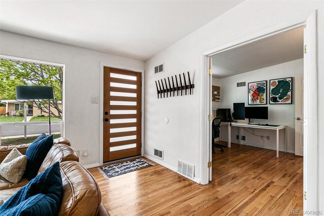 a living room with furniture and a wooden floor
