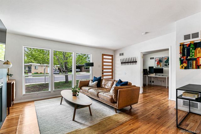 a living room with furniture and a wooden floor