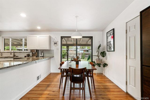 a kitchen with a dining table chairs and refrigerator