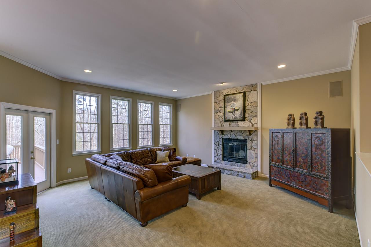 12312 Galway Drive Raleigh, NC 27613 - Photo 4 of 25 Cozy up next to the stone front fireplace in the family room or enjoy the wooded views from the wall of windows. Family Room