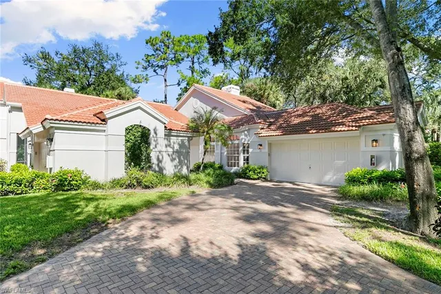 a view of a house with a yard and large tree