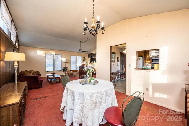 a view of a dining room with furniture a chandelier and a window