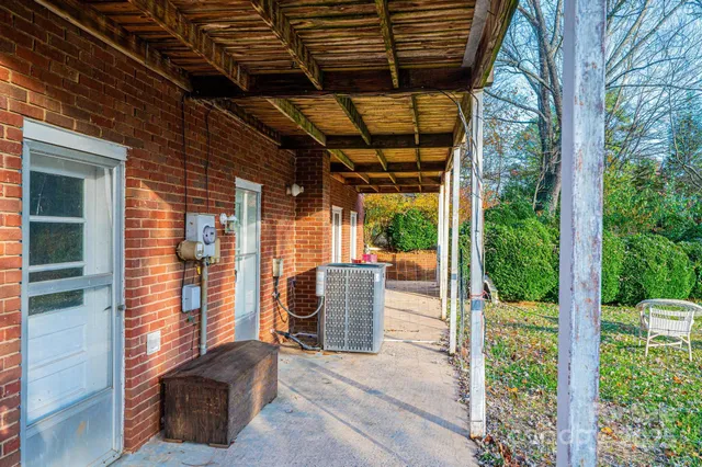 a view of a house with a yard and large trees