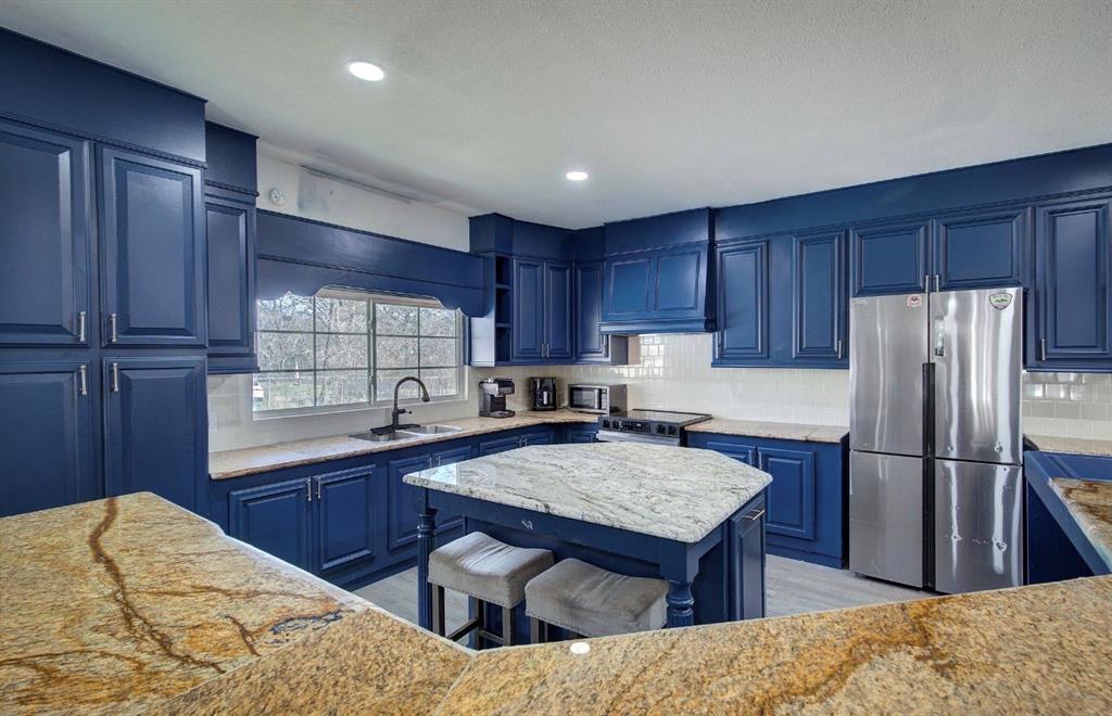 11291 Goss Street Wills Point, TX 75169 - Photo 14 of 23 a kitchen with stainless steel appliances granite countertop a refrigerator sink and wooden cabinets