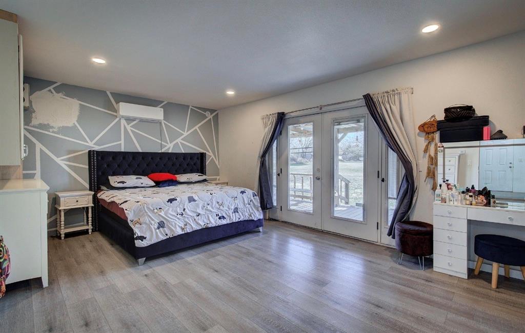 11291 Goss Street Wills Point, TX 75169 - Photo 20 of 23 a bedroom with a bed a large window and wooden floor