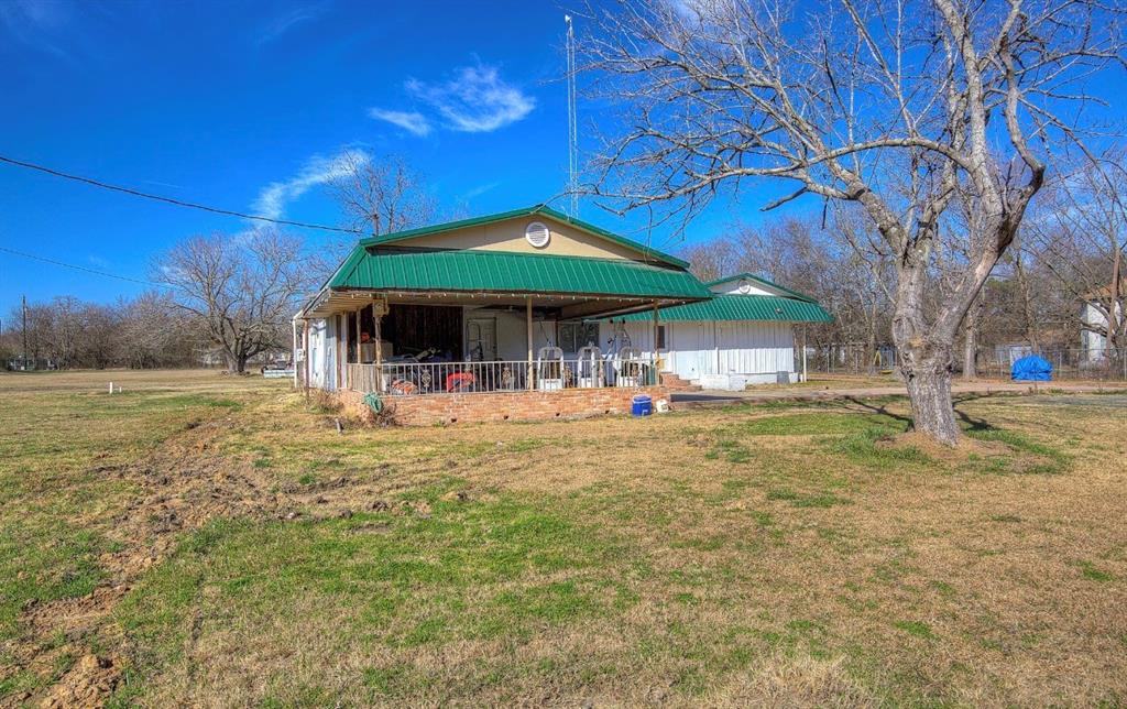 11291 Goss Street Wills Point, TX 75169 - Photo 4 of 23 a backyard of a house with table and chairs under an umbrella