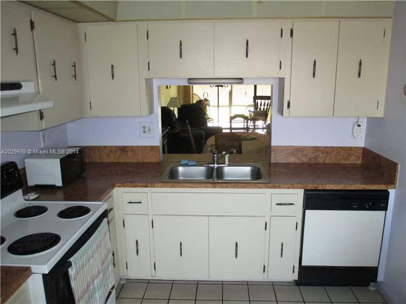 745 Banks Road, Unit 745 Margate, FL 33063 - Photo 3 of 13 a kitchen with white cabinets and appliances