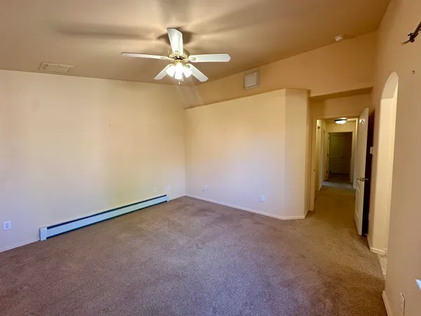 an empty room with a chandelier fan and a chandelier fan