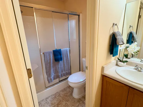 a bathroom with a sink a toilet a mirror and shower