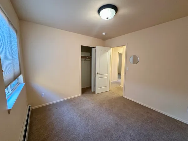 an empty room with closet and windows