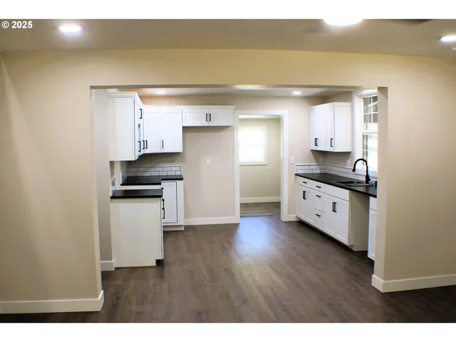 a kitchen with granite countertop a sink and cabinets