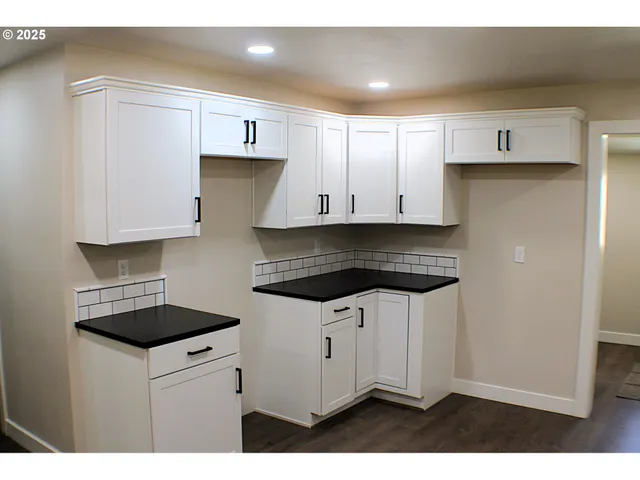 a kitchen with kitchen island granite countertop a sink and wooden cabinets
