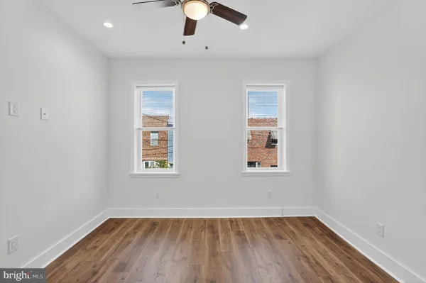 an empty room with a window and wooden floor