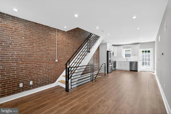 a view of a hallway with wooden floor and furniture