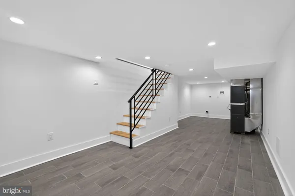 an empty room with wooden floor and white walls