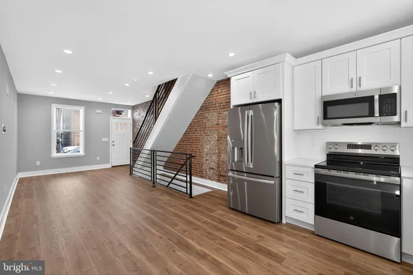 a kitchen with stainless steel appliances a refrigerator a stove a microwave and wooden floors
