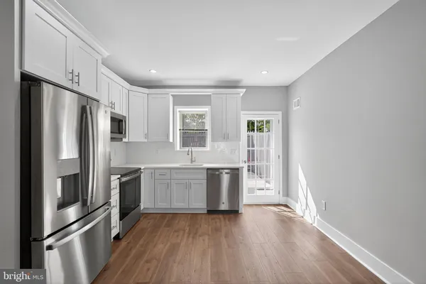 a kitchen with stainless steel appliances a refrigerator sink and stove
