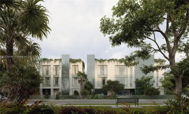 a front view of a residential apartment building with a yard and palm trees