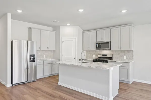 a kitchen with stainless steel appliances a refrigerator stove microwave and cabinets