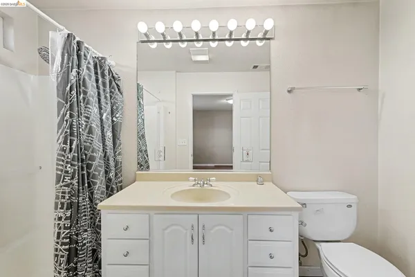 a bathroom with a sink a toilet and a mirror