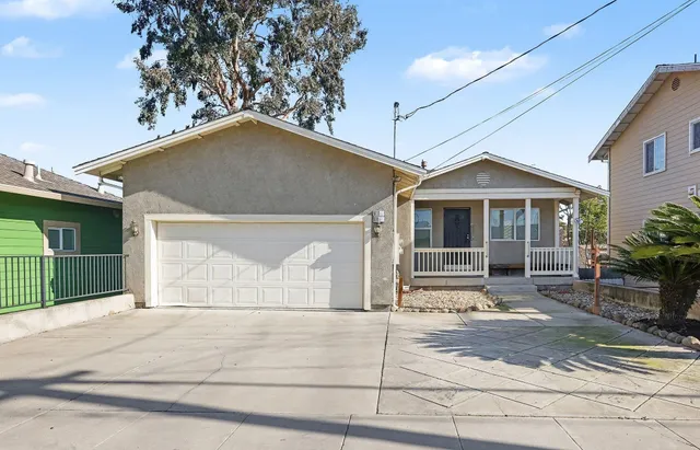 a front view of a house with a garden and garage