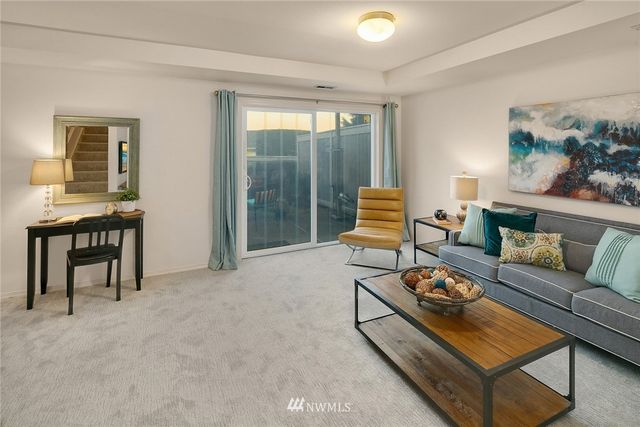 a living room with furniture and a floor to ceiling window