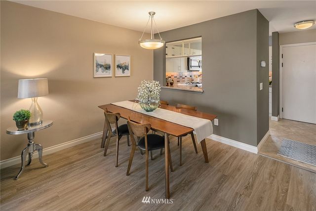 a dining room with wooden floor a chandelier a wooden table and chairs