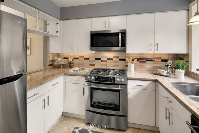 a kitchen with granite countertop a sink stove and refrigerator