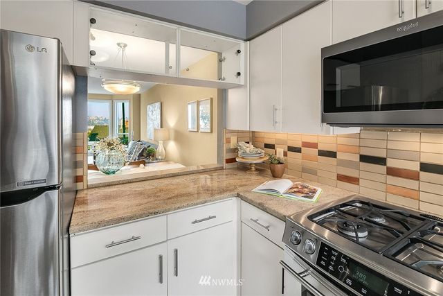 a kitchen with stainless steel appliances granite countertop a stove and a microwave