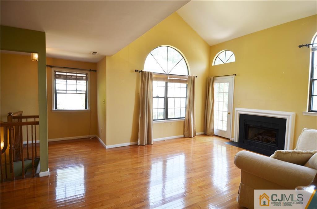 5206 Stonehedge Road Edison, NJ 08820 - Photo 2 of 13 a view of an empty room with wooden floor and a fireplace