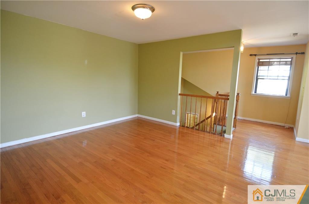 5206 Stonehedge Road Edison, NJ 08820 - Photo 5 of 13 a view of an empty room with wooden floor and a window