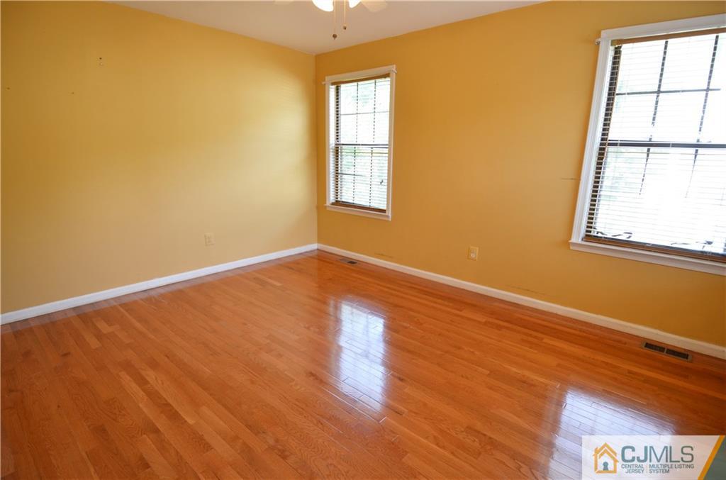 5206 Stonehedge Road Edison, NJ 08820 - Photo 7 of 13 a view of an empty room with wooden floor and a window