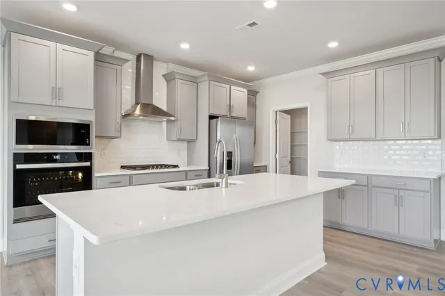 a kitchen with kitchen island a sink stainless steel appliances and cabinets