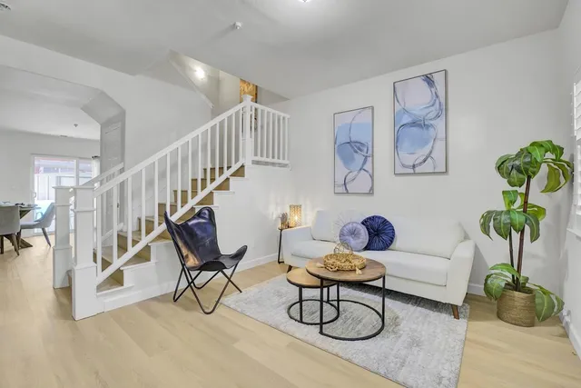 a living room with patio plants and wooden floor