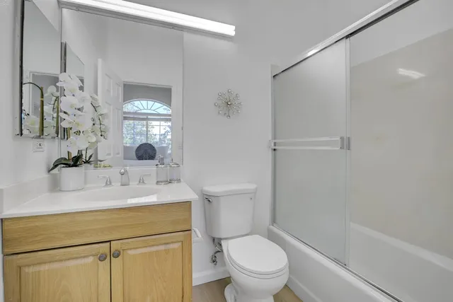 a bathroom with a sink toilet vanity and shower